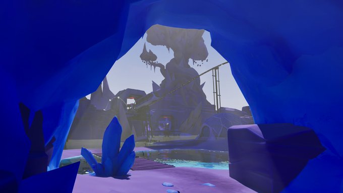 A vibrant 3D rendered scene viewed from inside a blue cave looking out at a fantasy landscape with crystal formations, water, and a large structure in the distance.