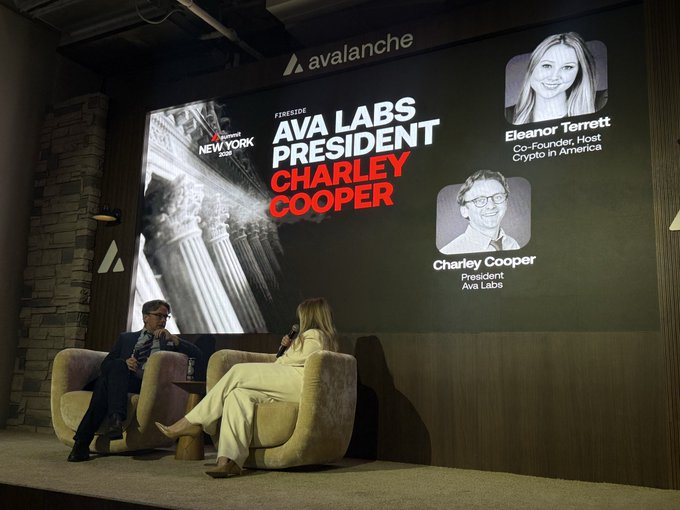 Fireside chat stage at an Avalanche crypto event featuring 'AVA LABS PRESIDENT CHARLEY COOPER', with speakers seated in beige armchairs and a large screen showing Charley Cooper and moderator Eleanor Terrett.
