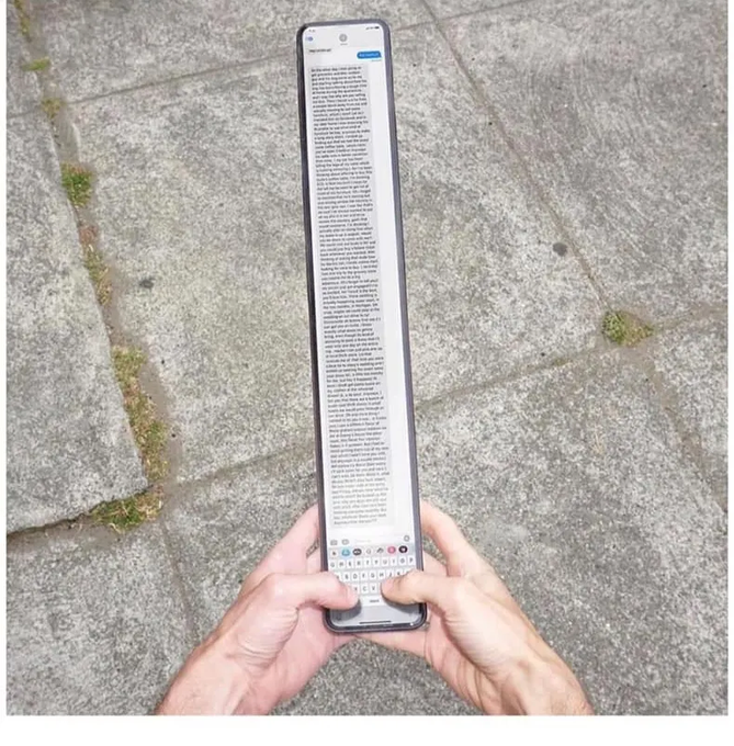 A person's hands hold a long, unusually tall smartphone displaying what appears to be the iPhone's full terms and conditions text on its screen.