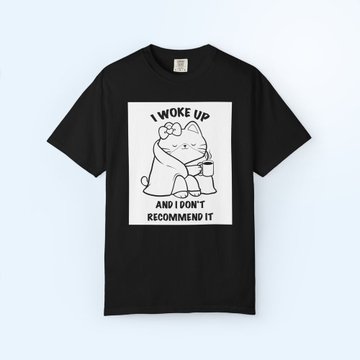 A black t-shirt featuring a line drawing of a cat with the text 'I WOKE UP AND I DON'T RECOMMEND IT'.