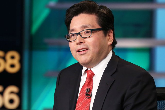 An Asian man wearing glasses, a dark suit, and a red tie appears on a CNBC television set, likely being interviewed for a financial news segment.