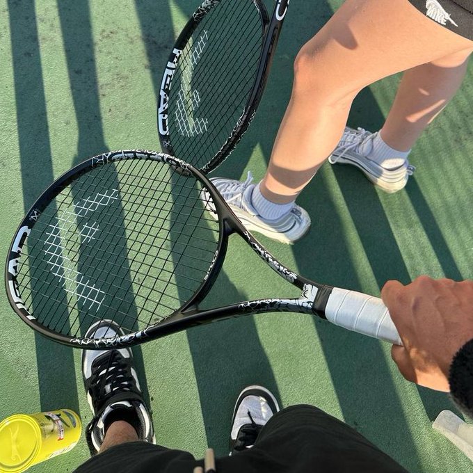 Two people are holding tennis rackets on a court, with the HEAD brand visible on one racket. The image relates to the "GM Chads" post by showing a common activity associated with a relaxed or athletic lifestyle often implied by such slang.