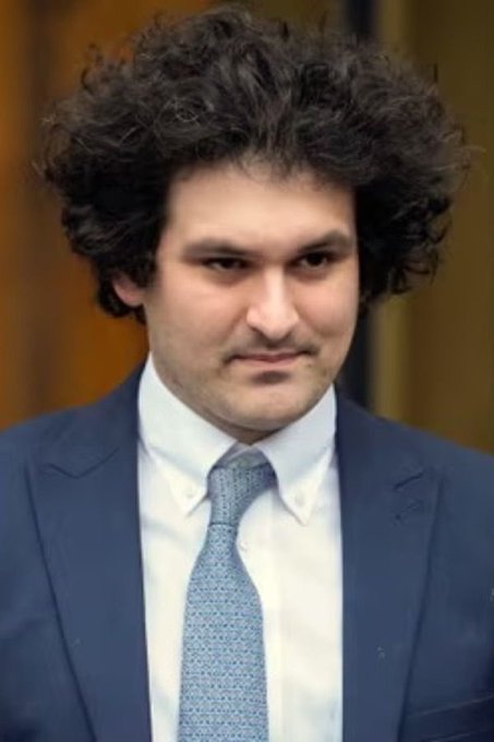 The image features a man wearing a suit, tie, and jacket with his hair styled into an afro. The man appears to be looking off into the distance or deep in thought. In the background of the photo, there are several other people present but they are not the main focus of the image. The post includes information about Robinhood, which is a cryptocurrency exchange platform that has gained significant attention and value over time. The post also mentions investing $500M in Anthropic worth tens of billions today and $7.6B in Robinhood worth about $7B today.