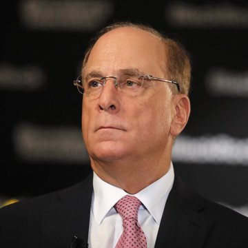A photograph of Larry Black, an American businessman, wearing glasses, a dark suit, and a pink tie.
