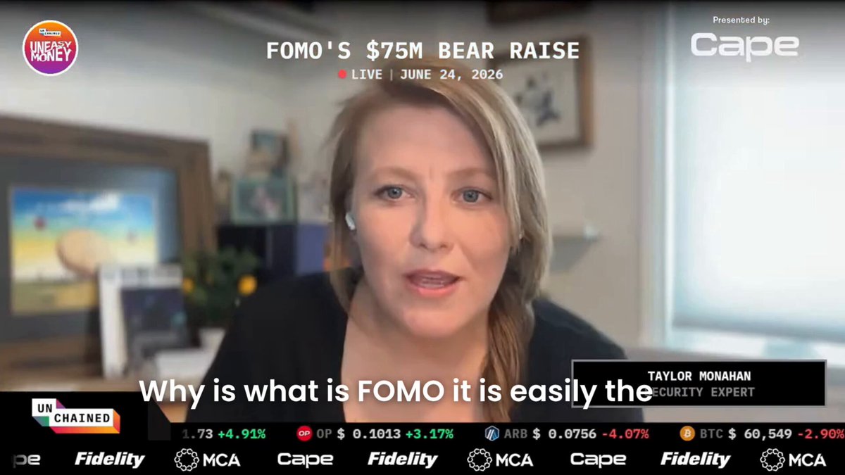 The image shows a woman sitting at a desk with a TV screen behind her. The TV screen displays an advertisement for FOMO trading app, which has caught the attention of the viewer. The text on the screen reads "FOMO is easily the most impressive mobile onchain trading app out there by a Texas mile. These two founders are absolute killers" and "Focus on what is in the image and how it relates to the post". This advertisement seems to be promoting the FOMO app, highlighting its features and benefits for users who want to stay up-to-date with the latest trends and news.