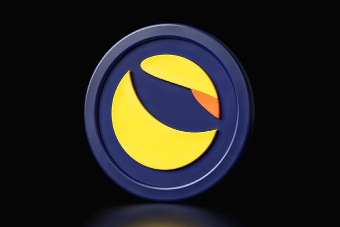 A 3D rendered logo featuring a stylized yellow crescent shape with an orange accent inside a dark blue circular badge, set against a black background. This represents the Terra Classic (LUNC) cryptocurrency branding.