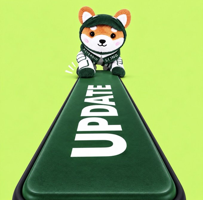 A plush Shiba Inu toy wearing a green beanie and a scarf labeled 'ASTERIOD LONG' sitting on a green track or runway with the word 'UPDATE' written in large white letters. The background is a bright lime green color.