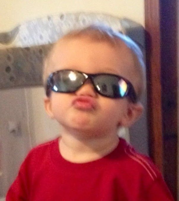A young child wearing oversized sunglasses makes a playful "duck lips" face while sporting a red shirt, seemingly embodying the confident and forward-looking spirit expressed in the caption about Nomisma Network's efforts to build a scalable AI and DeFi infrastructure for the future.