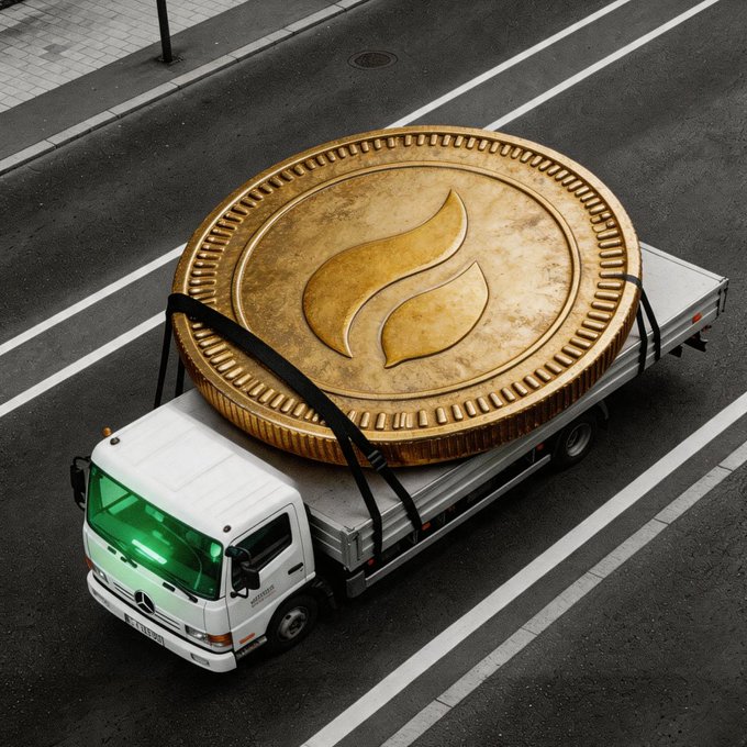The image features a white truck with a large gold coin strapped to its back, driving down a street. A green light can also be seen on the front of the truck. The text "GM Everything will be fine." appears below the image, which is likely an advertisement or promotional message related to GM's brand or product.