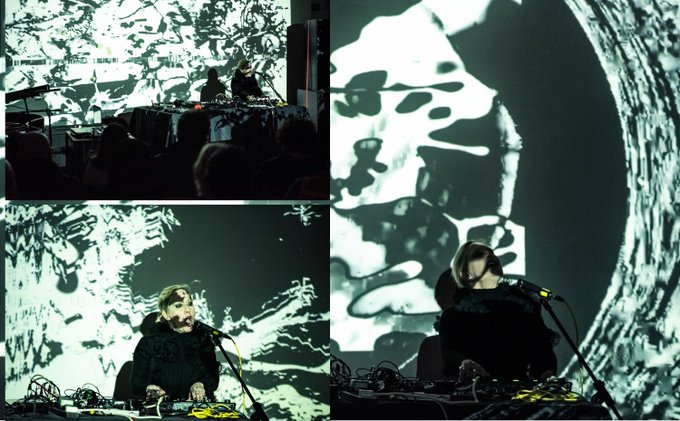 A collage of three images shows an artist performing live with electronic equipment in front of large projections of swirling, abstract black-and-white visuals, with audience members visible in silhouette watching the show. The setup reflects the described live video performance titled "Disintegrating Landscapes," showcasing the immersive, experimental audiovisual art created by @eglesaka for the objktcom-based exhibition.