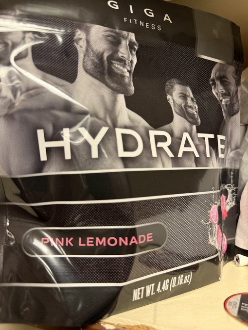 The image shows a black and white bag of pink lemonade, which has been tagged with the word "giga" at the bottom left corner. The bag also features an advertisement for Giga Fitness, suggesting that the product might be related to fitness or health.