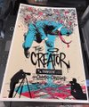 The image shows a colorful screen-printed poster for "The Creature," featuring bold blue and red artwork on a cream background, displayed against a cluttered room setting. Visible text includes "THE CREATURE," "Transient Labs," "Drop Tomorrow," and "akachambo," which ties to the user's mention of their upcoming collaborative print drop.