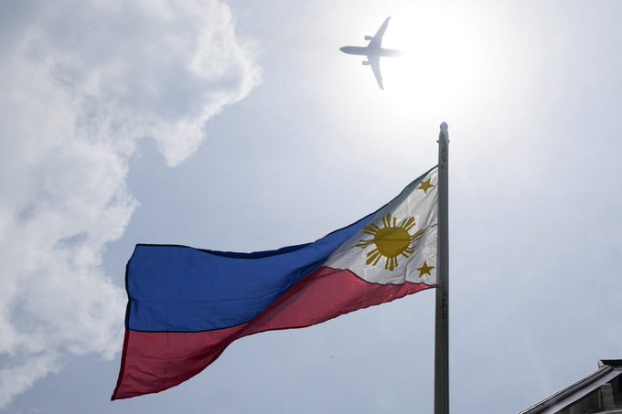 The image features a flag flying high against a blue sky with clouds. Below the flag, there's an airplane flying at a low altitude. The text "Just In" suggests that this information might be recent or newly published. The SEC has shown interest in the Real World Assets market, and more countries are showing real interest in RWA'S. This implies that the market is growing rapidly and attracting attention from various stakeholders.
