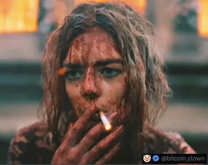 A bloodied and disheveled woman smoking a cigarette stares intensely at the camera in this cinematic-style image. The image serves as a gritty, satirical visual meant to accompany a post mocking "Americans admiring the new Trump coin."