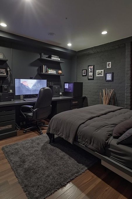 A dimly lit bedroom featuring a dark computer setup with dual monitors against a black accent wall, alongside a neatly made bed with dark bedding and a black area rug on wooden floors. The moody, "goodnight"-themed setting matches the post's evening vibe, showcasing the personal space of the @River4fun community member.