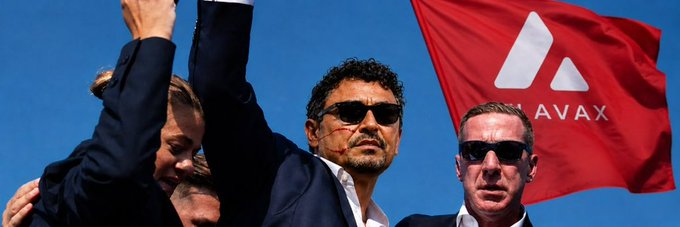 The image features a group of three men standing together with their arms raised high above their heads. They are all wearing suits and sunglasses, giving off an air of confidence and success. The background of the photo shows a red flag with the word "avax" written on it in white letters. The post includes a caption that reads: "the summer energy on the avax timeline been feeling different lately you can just tell when a community is genuinely having fun again, memes everywhere, edits all over the timeline, people showing love before launch even happens that's the thing about @avax".