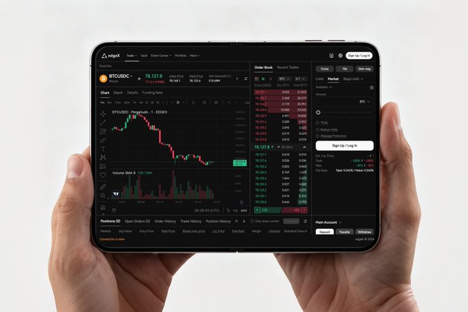A pair of hands holds a tablet displaying the EdgeX trading platform, showing a BTCUSDC chart with candlestick patterns, an order book, and a "Sign Up / Log In" prompt against a dark interface. The image reinforces the "bigger picture, higher performance" message by showcasing the platform's ability to deliver a comprehensive, high-function trading experience on a larger mobile screen.