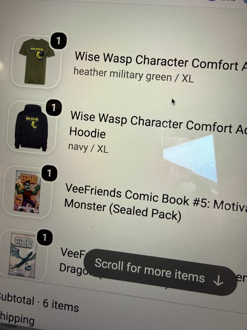 A screenshot of an online shopping cart containing Wise Wasp Character Comfort Apparel items and VeeFriends Comic Books, with a 'Scroll for more items' prompt visible.