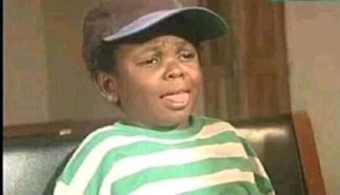 The image shows a young boy wearing a backwards baseball cap and a green and white striped shirt, making a skeptical or unimpressed facial expression. The meme format aligns with the post's tone of doubt, humorously conveying disbelief at someone's request for more bag screenshots from $ANSEM.