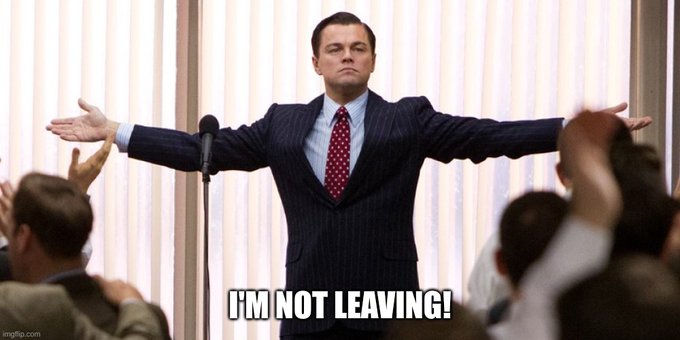 Leonardo DiCaprio stands with arms outstretched in a motivational pose from "The Wolf of Wall Street," with the caption "I'M NOT LEAVING!" — a meme used by the XRP community to express unwavering commitment to holding the token despite price struggles.