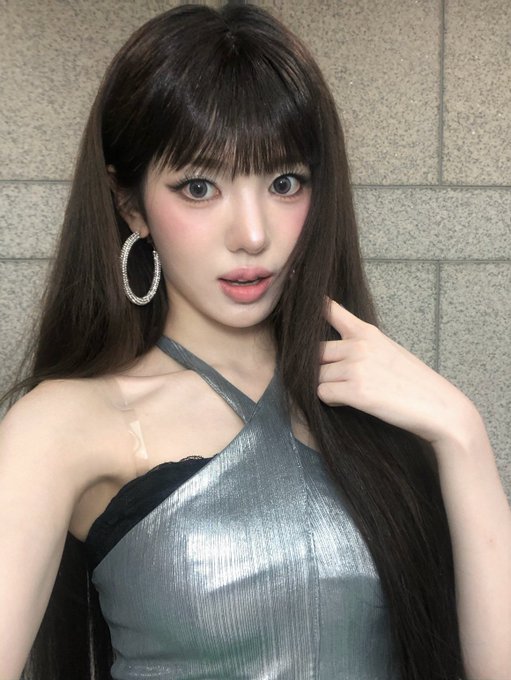 A young woman with long dark hair, large hoop earrings, and bold makeup poses against a gray tiled wall, wearing a shiny silver halter top. The caption "260901 Bubble #Sui" suggests this is a fan-taken photo from September 1, 2026, possibly referencing the K-pop idol Sui in a fan-edited "bubble" style.