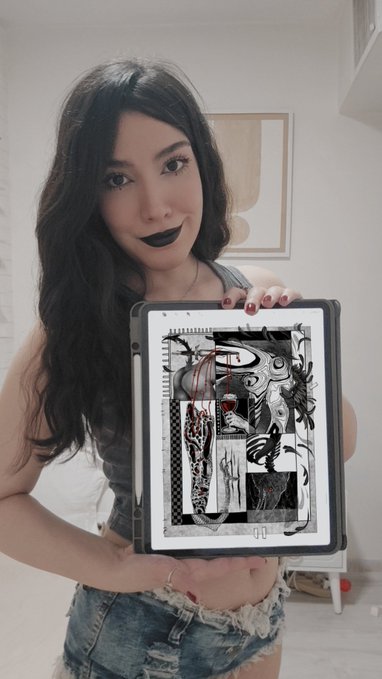 A young woman with dark gothic makeup holds up a tablet displaying an intricate black-and-white surrealist digital drawing in what appears to be an art app.