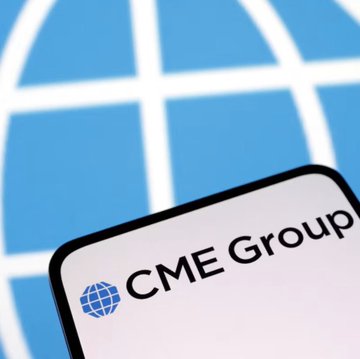 A smartphone displaying the CME Group logo on a screen, positioned in front of a blue globe graphic.