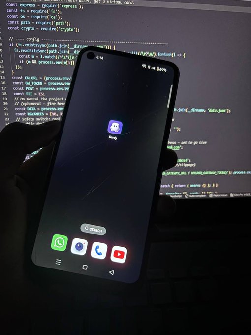 A smartphone resting on a laptop keyboard, displaying a Discord app icon on its home screen, with lines of code visible on the laptop monitor behind it.