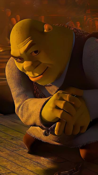 A close-up of the animated character Shrek in a medieval setting, wearing a tunic and vest with his hands clasped together.