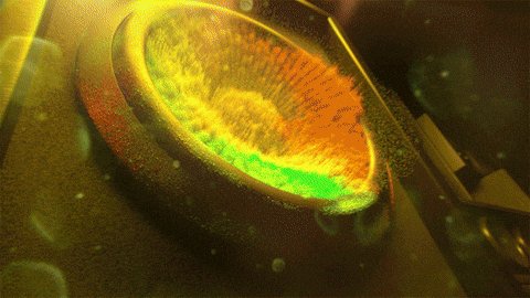 urn of yellow and orange liquid with a green center, surrounded by bubbles and steam.