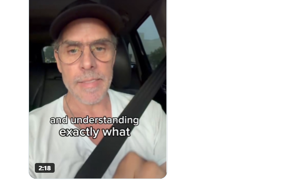 A selfie-style video still of a man wearing glasses and a cap sitting in a car with a seatbelt on, with the caption "and understanding exactly what" and a 2:18 timestamp.
