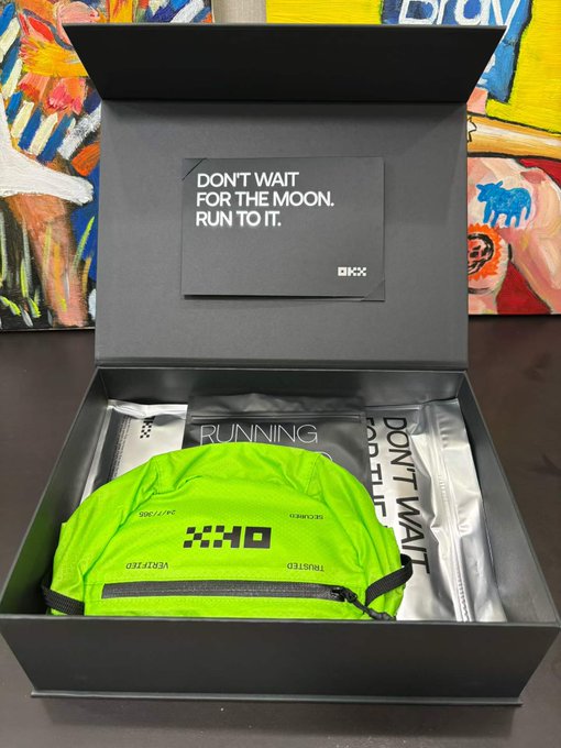 An unboxed OKO running kit featuring a neon green running belt and a card reading 'DON'T WAIT FOR THE MOON, RUN TO IT.'