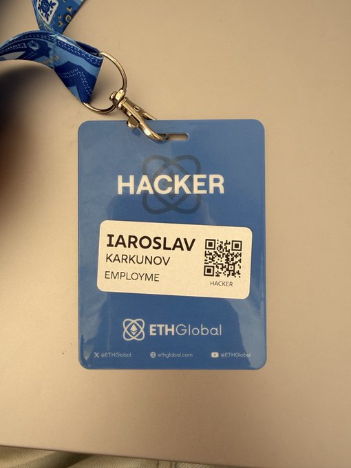 A blue conference badge for ETHGlobal reads 'HACKER' with the name 'IAROSLAV KARKUNOV,' featuring a QR code, the ETHGlobal logo, and a blue lanyard attached to a clip.