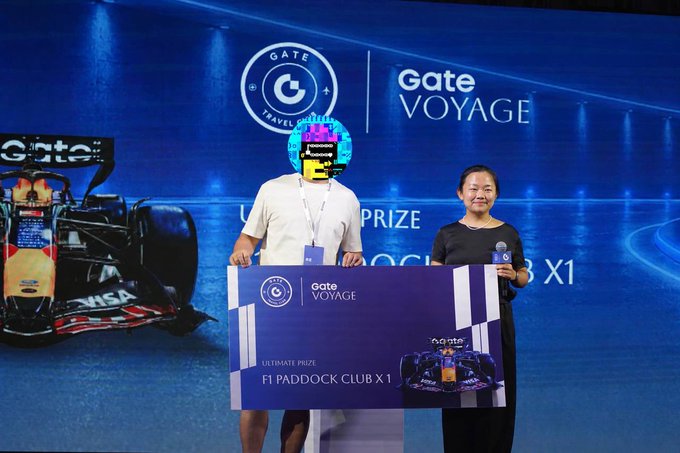 Two people pose on stage holding an oversized "Gate Voyage Ultimate Prize" placard for an "F1 Paddock Club X1" experience, with the Gate logo and an Oracle Red Bull Racing F1 car displayed on the backdrop—visually representing the F1 VIP tickets and Red Bull sponsorship referenced in the post.