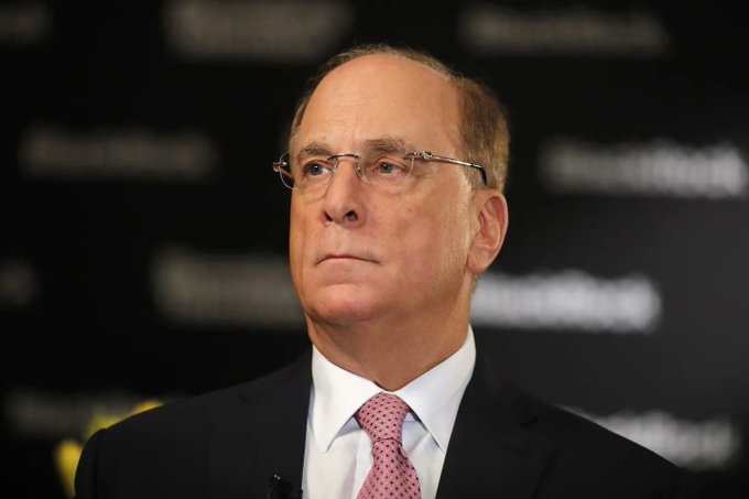 Larry Fink, CEO of BlackRock, appears serious at a podium during a Forbes event, contextualizing the news that his firm has sold nearly $1 billion in Bitcoin over the past week, signaling a bearish outlook for $BTC.