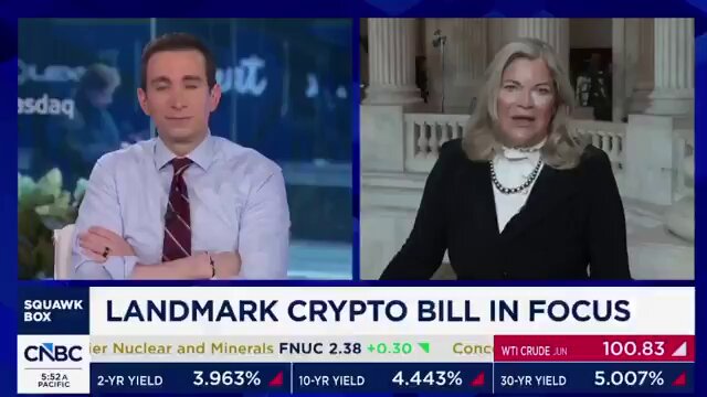 The image shows a news segment featuring two people, one man wearing a tie and another woman with blonde hair. They are both sitting at a desk, appearing engaged in conversation or discussing an issue. The background of the scene includes text that reads "Landmark Crypt Bill In Focus", which suggests that they might be talking about a recent bill related to cryptocurrency or blockchain technology. Additionally, there is text that says "CNBC", indicating that this discussion could be taking place on a news program broadcasted by CNN.