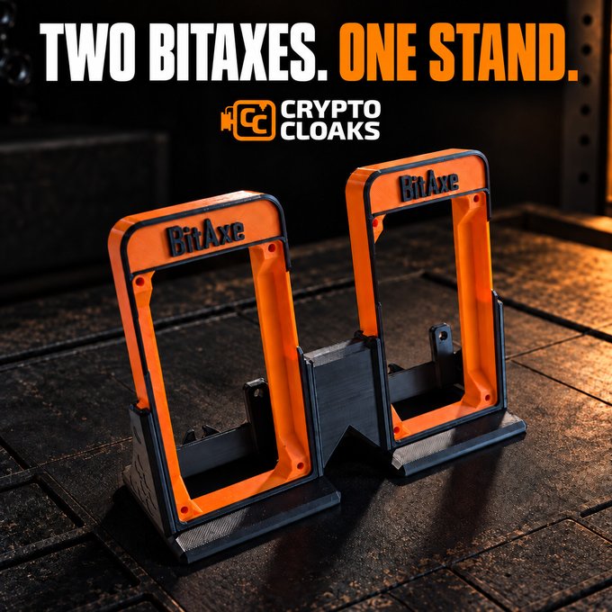 An advertisement showing two orange and black BitAxe crypto mining devices mounted together in a dual stand by Crypto Cloaks, with the text 'TWO BITAXES. ONE STAND.'