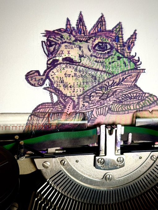 A close-up of a typewriter with a sheet of paper showing a colorful, hand-drawn map illustration featuring the text 'TOA BA', 'Dr. Hobo', and 'Pipe tI' in purple and green ink.