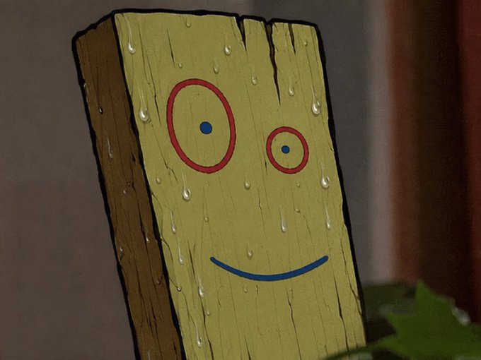 A wooden plank painted yellow with a simple face—two red circle eyes and a blue smiling mouth—drips with water droplets in a dark setting.