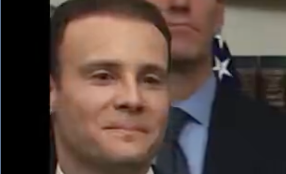 A man with a smug, self-satisfied expression looks slightly off-camera, while an American flag and another person are visible behind him. The "mfw the bags are loaded BIGLY" caption humorously pairs with his confident smirk, suggesting a triumphant or mischievously pleased reaction to something prepared and ready to go.