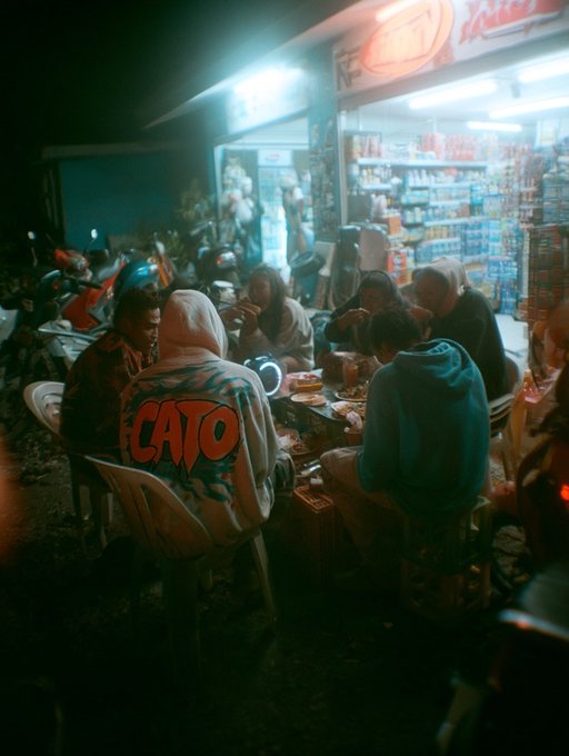 iced tea and soda are available at a bustling outdoor market, with people seated around tables under bright lights.