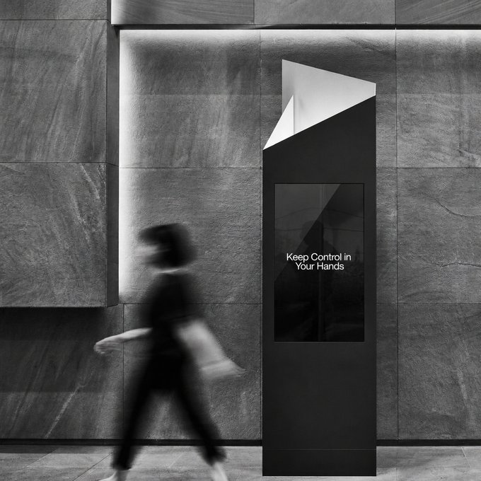 A blurred figure walks past a sleek digital kiosk displaying the message "Keep Control in Your Hands," reinforcing the post's message about self-custody and the importance of holding your own keys to maintain true control.