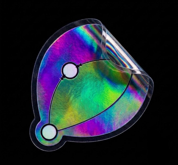 An iridescent holographic visor or mask with a rainbow color-shifting finish against a black background.