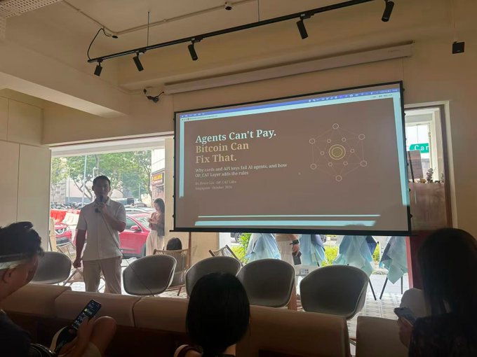 A speaker presents at a tech event with a projected slide reading "Agents Can't Pay, Bitcoin Can Fix That - Why Bitcoin and AI keys fit AI agents, and how BTC CAT Layer adds the rules" by Jin from CAT Labs (Singapore, October 2024), connecting to the post's theme of TOKEN2049 networking and discussion around Bitcoin's emerging role alongside AI agents.
