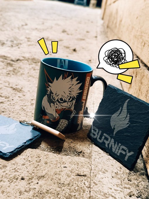 A black coffee mug featuring a spiky-haired anime character labeled "KATSUYA" and a slate coaster branded "BURNIFY" sit on a concrete surface with playful comic-style graphic overlays, complementing the upbeat "Good Morning Legends! Wagmi!" greeting with a fun, energetic vibe.