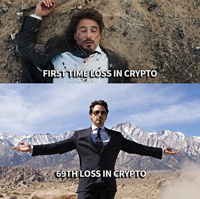 A two-panel meme featuring Tony Stark from Iron Man: in the top image he lies bloodied and defeated in dirt with the caption "FIRST TIME LOSS IN CRYPTO," while the bottom image shows him standing confidently with arms outstretched against a mountain backdrop with "69TH LOSS IN CRYPTO." The meme humorously illustrates the post's sentiment that even after 69 (or 100) consecutive $BTC losses, one can still maintain a calm, zen-like acceptance as if the losses don't feel real.
