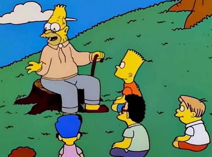 A scene from The Simpsons showing Grampa Simpson sitting on a tree stump with a cane, telling a story to Bart, Milhouse, and another child on a grassy hill.