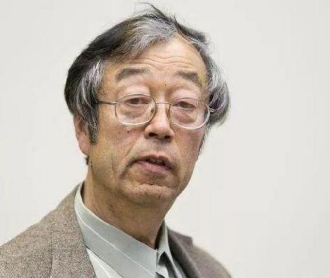 A portrait of an elderly East Asian man with grey hair and glasses, wearing a grey jacket.