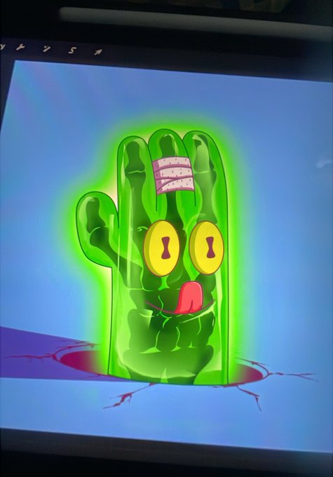 A cartoon green hand with a bandaged finger, glowing eyes, and a tongue sticking out appears on screen. The vibrant, surreal artwork visually represents the quirky, collectible nature of an artist's debut NFT collection being introduced.