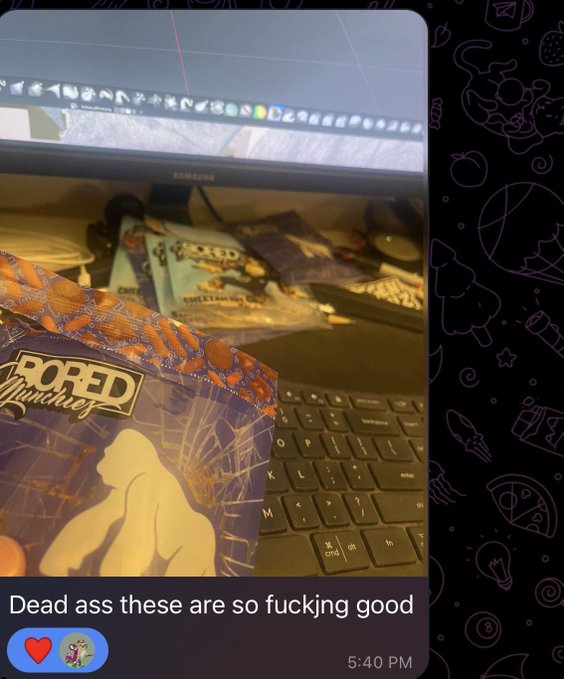 A Snapchat photo of an opened 'BORED Monkey' chocolate bar resting on a laptop keyboard, with the caption 'Dead ass these are so fucking good'.